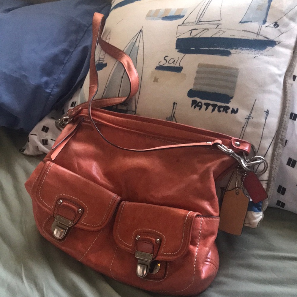 This vintage leather orange coach bag is beautiful. Has rain spots Can b cleaned